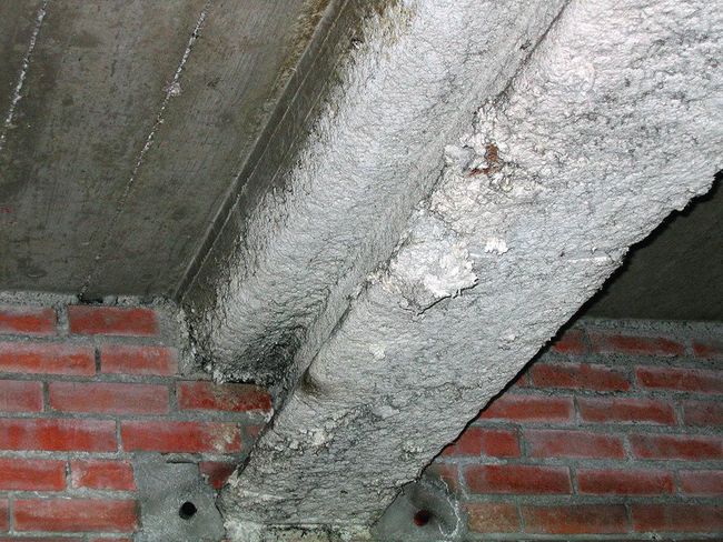 Sotto un soffitto in cemento si trovano due rivestimenti in amianto spruzzato.